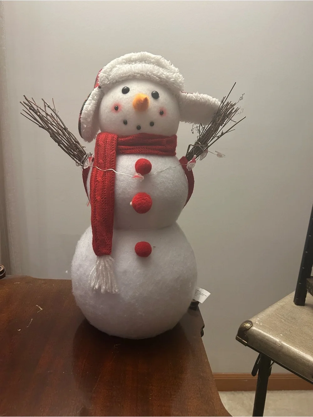 Snowman decoration with twig arms, plaid hat and Santa accent lights New